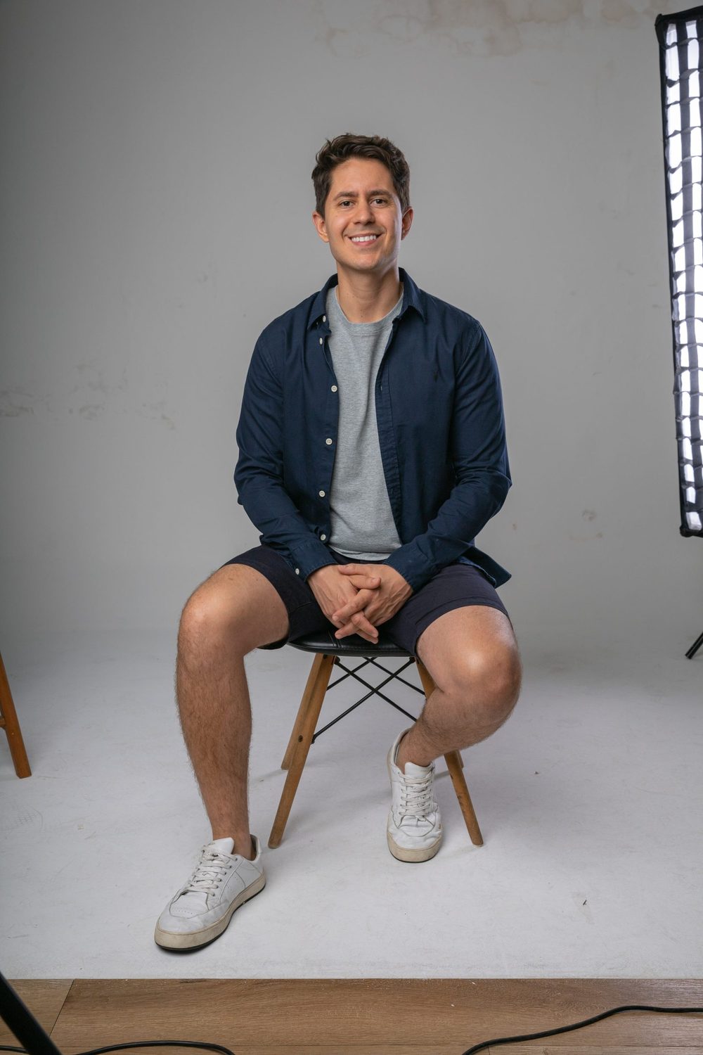 Gio Braga seated on a stool, studio portrait