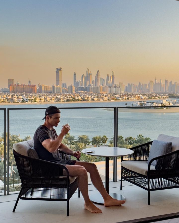 Gio on a balcony overlooking a city skyline